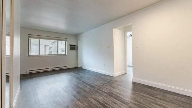 Empty apartment with dark wood floors and window living room at Victory at Burcham Place in East Lansing Student Accommodation