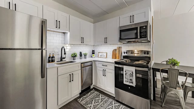Modern kitchen with stainless steel appliances dining table kitchen at Victory at Burcham Place in East Lansing Student Accommodation