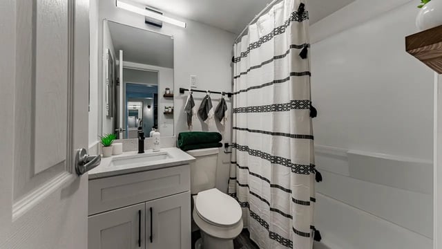 Modern bathroom vanity toilet and shower curtain Bathroom at Victory at Burcham Place in East Lansing Student Accommodation