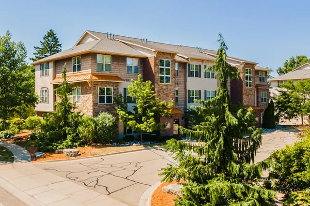 Apartment building with stone and siding exterior exterior at Victory at Burcham Place in East Lansing Student Accommodation