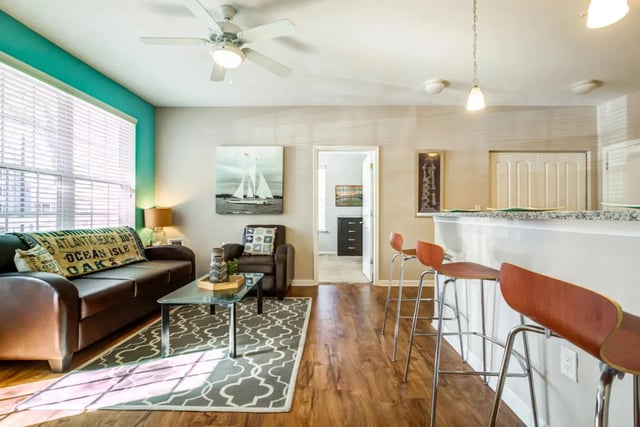 Sofa coffee table armchair bar stools living area at The Nest at 4955 in Wilmington Student Accommodation