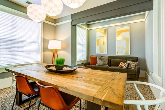 Wooden dining table orange chairs living room. at The Nest at 4955 in Wilmington Student Accommodation
