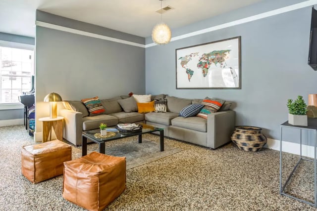 Sectional sofa map wall two leather poufs living room at The Nest at 4955 in Wilmington Student Accommodation