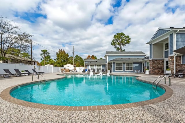 Blue swimming pool with lounge chairs outside Exterior at The Nest at 4955 in Wilmington Student Accommodation