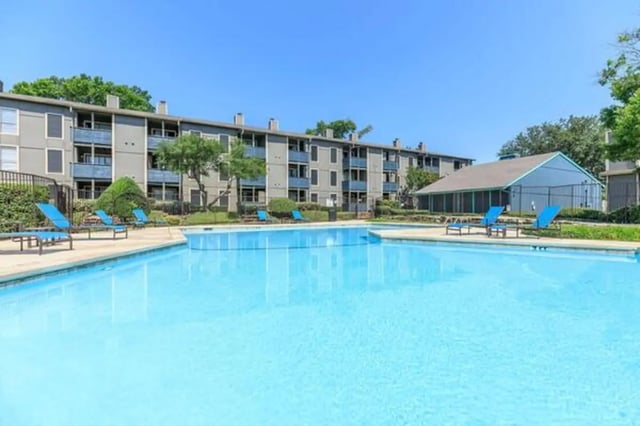 Apartment building with pool and lounge chairs exterior at Villas at Alameda in Fort Worth Student Accommodation