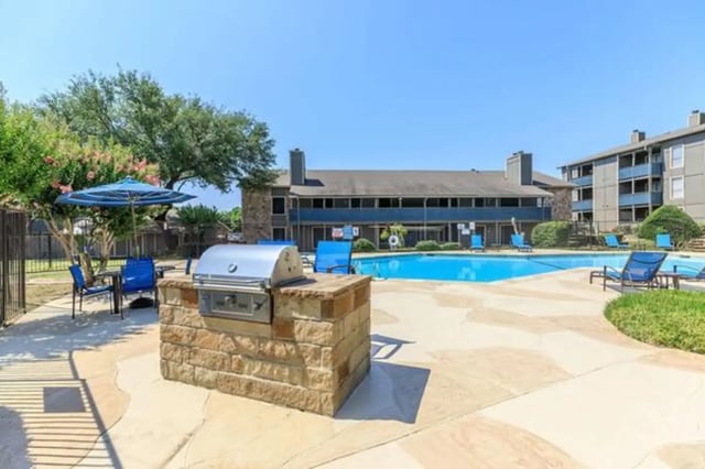 Grill pool chairs and umbrella outdoor area at Villas at Alameda in Fort Worth Student Accommodation
