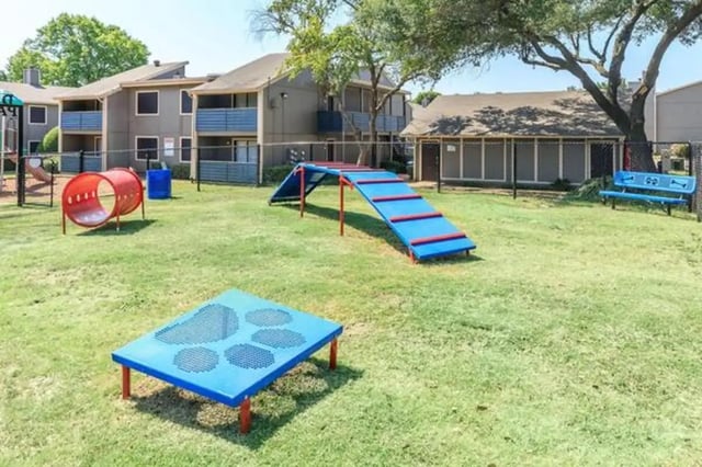 Dog park features red tunnel blue agility ramp and bench Dog park at Villas at Alameda in Fort Worth Student Accommodation