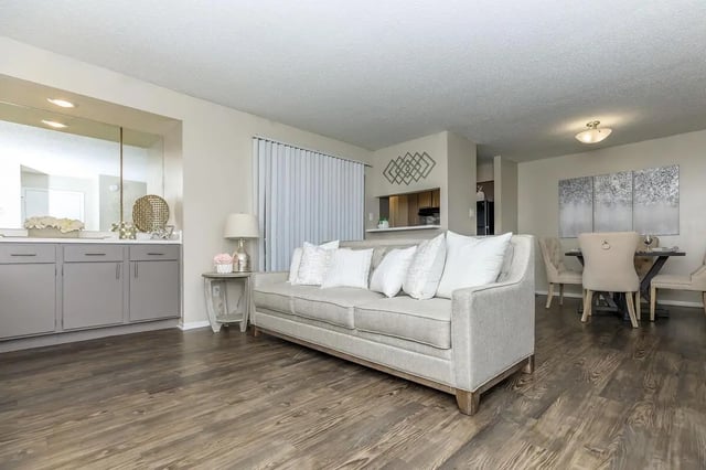 Gray couch dining table and kitchen living room at Villas at Shadow Oaks in Austin Student Accommodation