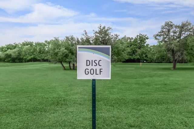 Disc golf sign on green lawn exterior at Villas at Shadow Oaks in Austin Student Accommodation