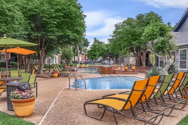 Pool lounge chairs trees and potted plants outdoor pool at Villas at Shadow Oaks in Austin Student Accommodation