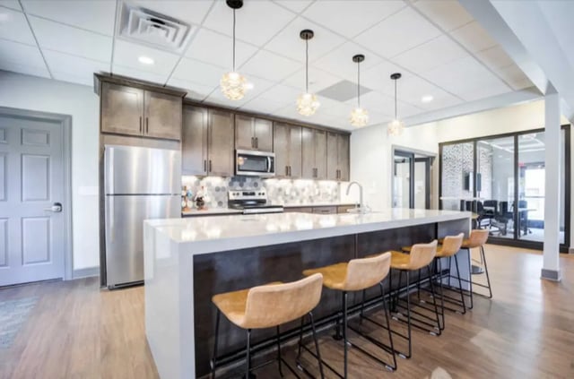 Kitchen island with stools and cabinets kitchen at Collegiate Suites of Blacksburg in Blacksburg Student Accommodation