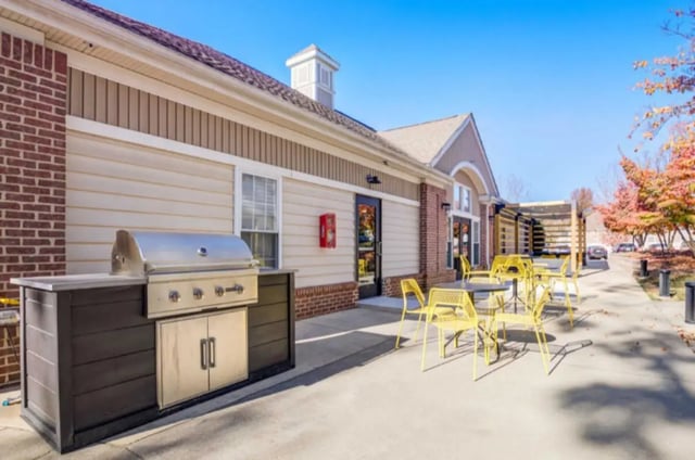 Grill with yellow chairs and tables outdoor area at Collegiate Suites of Blacksburg in Blacksburg Student Accommodation