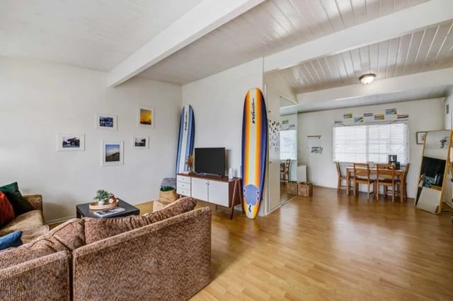 Sofa surfboards TV dining table living room at Solis Isla Vista in Isla Vista Student Accommodation