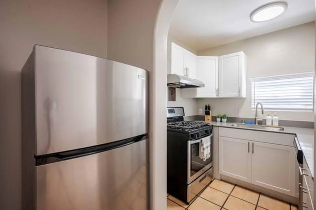 Stainless steel refrigerator gas stove white cabinets sink kitchen at Solis Isla Vista in Isla Vista Student Accommodation