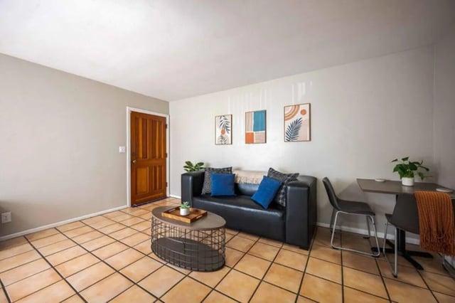 Black sofa oval coffee table three pictures living room at Solis Isla Vista in Isla Vista Student Accommodation