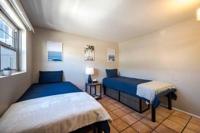 Two beds with blue bedding and white blankets bedroom at Solis Isla Vista in Isla Vista Student Accommodation