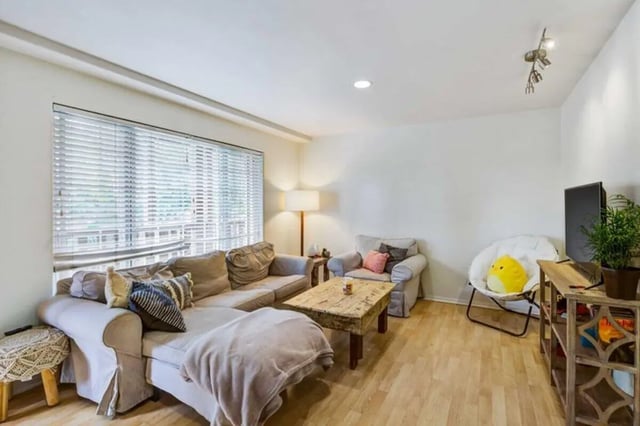 Sofa chairs coffee table with plant living room at Solis Isla Vista in Isla Vista Student Accommodation