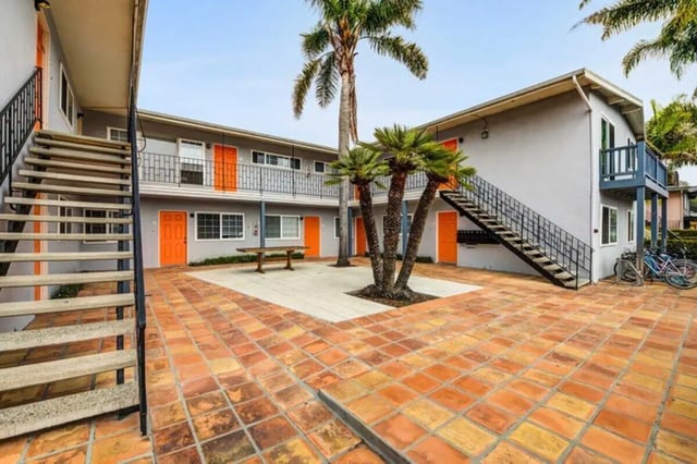 Courtyard with stairs orange doors bench exterior at Solis Isla Vista in Isla Vista Student Accommodation