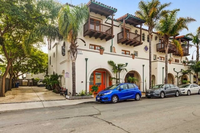 Spanish style building with cars outside exterior at Solis Isla Vista in Isla Vista Student Accommodation