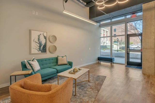 Teal sofa orange chair marble coffee table rug living room at The Ross Salisbury in Salisbury Student Accommodation