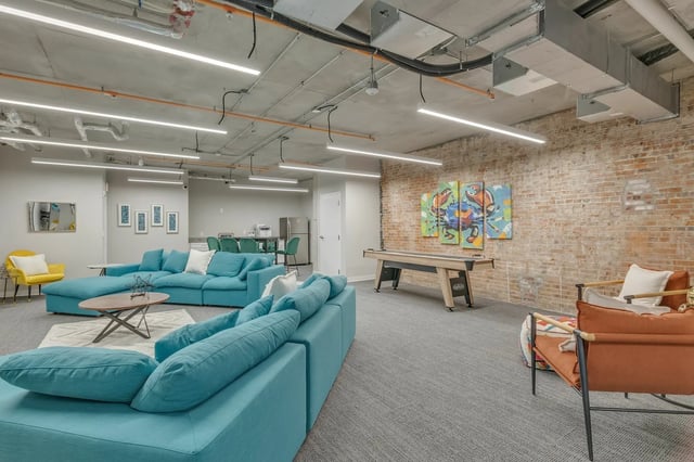 Turquoise sofas pool table and orange chair living room at The Ross Salisbury in Salisbury Student Accommodation