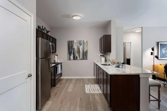 Stainless steel fridge dark cabinets marble island kitchen at Avoca in Louisville Student Accommodation