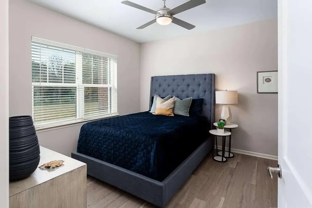 Tufted headboard dark blue bed bedside tables lamp bedroom at Avoca in Louisville Student Accommodation