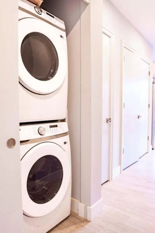 Stacked white washer dryer hallway with doors Laundry Room at 8th and High Columbus in Columbus Student Accommodation