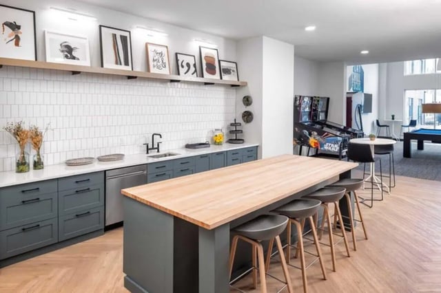 Kitchen island bar stools pinball machine pool table common area at Proxi Lawrence in Lawrence Student Accommodation