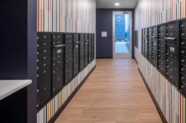Mailboxes along colorful striped hallway to door exterior at Proxi Lawrence in Lawrence Student Accommodation