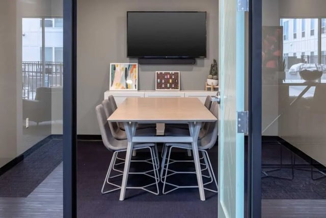 Table chairs TV artwork common area at Proxi Lawrence in Lawrence Student Accommodation