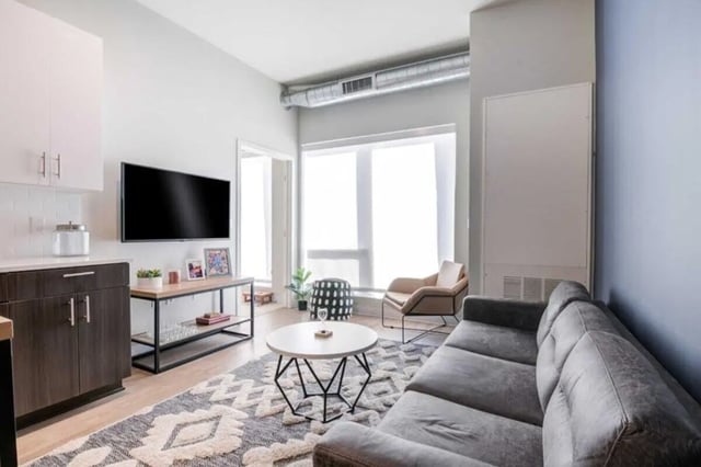 Sofa television table and armchair living room at Proxi Lawrence in Lawrence Student Accommodation