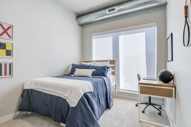 Blue bed with white blanket desk basketball Bedroom at Proxi Lawrence in Lawrence Student Accommodation