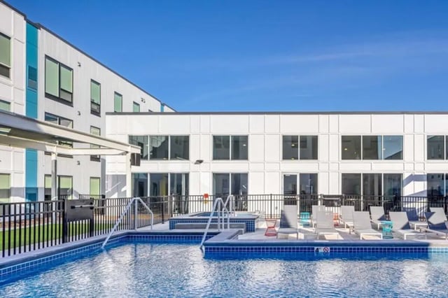 Pool lounge chairs and hot tub exterior. at Proxi Lawrence in Lawrence Student Accommodation