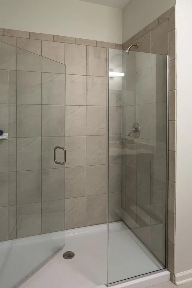 Glass shower stall tiled walls with shower head and handle bathroom at Frontgate in Louisville Student Accommodation