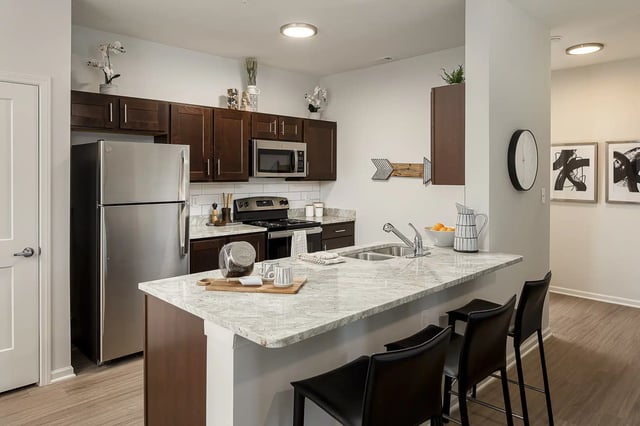 Stainless steel refrigerator dark cabinets and granite countertop kitchen at Frontgate in Louisville Student Accommodation