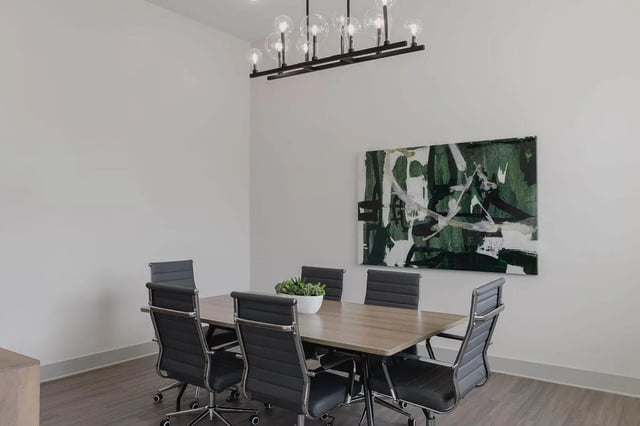 Table chairs plant painting modern chandelier meeting room at The Belltower in Louisville Student Accommodation