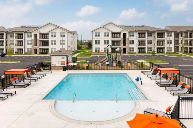 Pool playground lounge chairs apartment buildings exterior at The Belltower in Louisville Student Accommodation