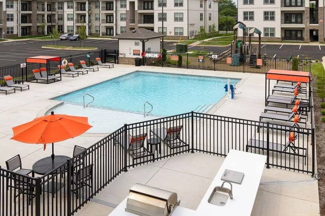 Pool lounge chairs umbrella and grill area exterior at The Belltower in Louisville Student Accommodation