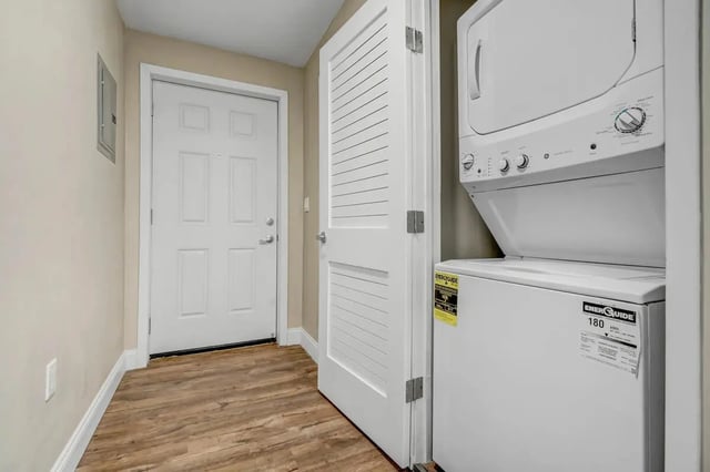 Stacked washer dryer unit and white door Laundry room at Flats on Elk in Glendale Student Accommodation