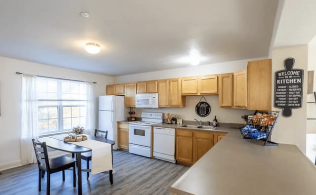 Dining table refrigerator stove dishwasher kitchen area at Copper Beech at Ames in Ames Student Accommodation
