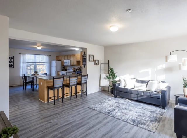 Kitchen island sofa rug and dining area living room at Copper Beech at Ames in Ames Student Accommodation