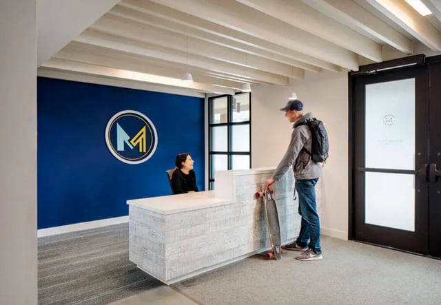 Reception desk with staff and visitor lobby at M @ College in San Diego Student Accommodation