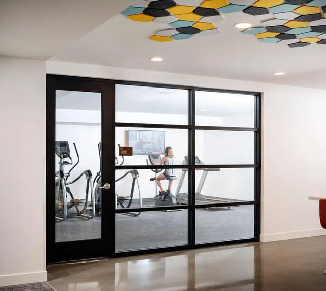 Fitness room with exercise machines and woman fitness room at M @ College in San Diego Student Accommodation