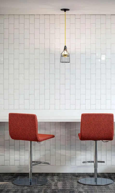 Two red chairs and pendant light kitchen at M @ College in San Diego Student Accommodation