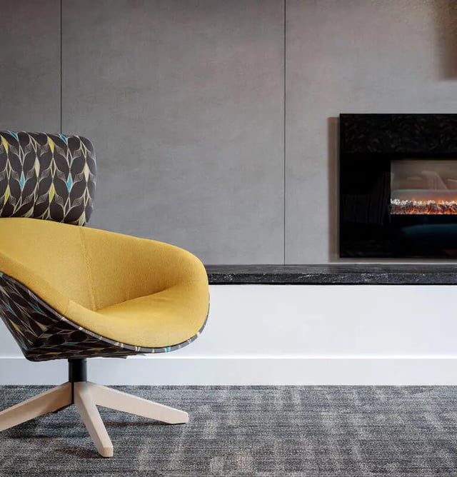 Yellow swivel chair with patterned back living room at M @ College in San Diego Student Accommodation