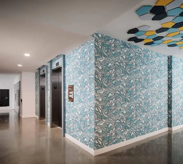 Hallway with elevators and patterned wallpaper hallway at M @ College in San Diego Student Accommodation