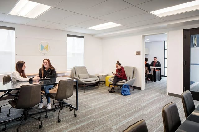 Students at a table with chairs common area at M @ College in San Diego Student Accommodation