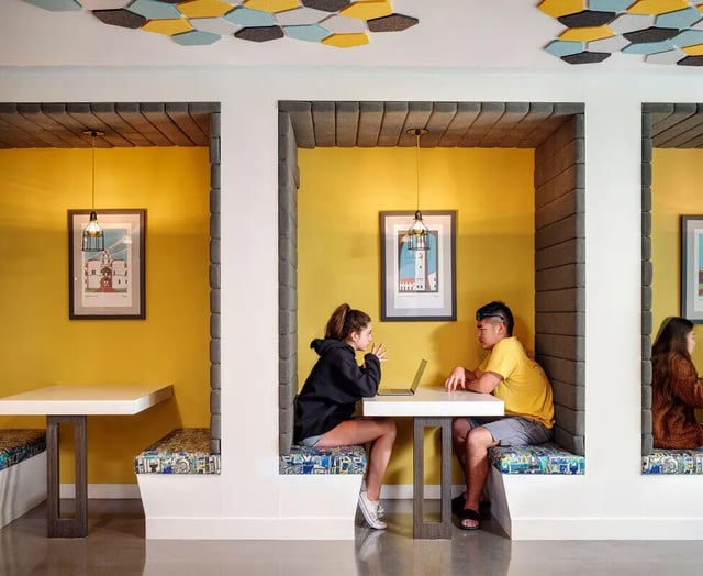 Students use laptops at colorful study booths living area at M @ College in San Diego Student Accommodation