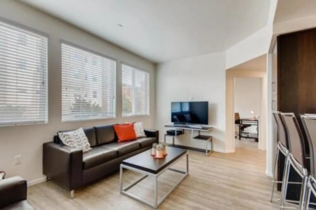 Black couch coffee table TV living room at Prisma in San Diego Student Accommodation